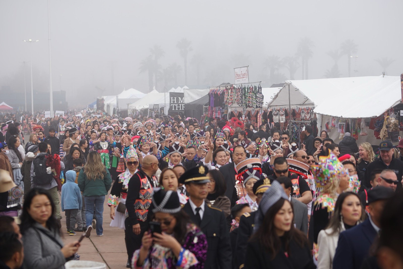 Crowds walking the fairgrounds between vendor tents at the Big Fresno Hmong New Year.